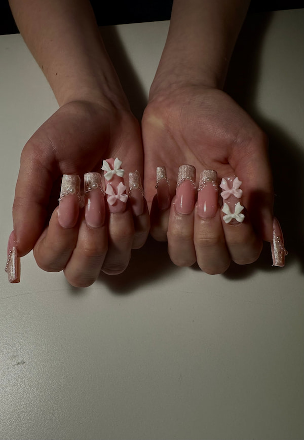pink glitter nail set with white and pink bows and gems